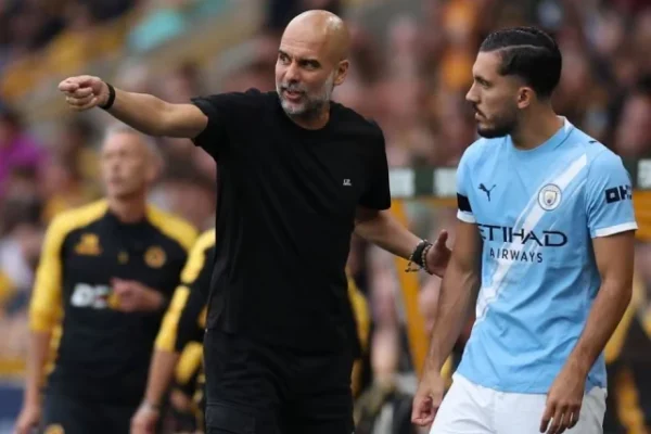 pep guardiola passes on instructions to rayan cherki before the substitute takes the field