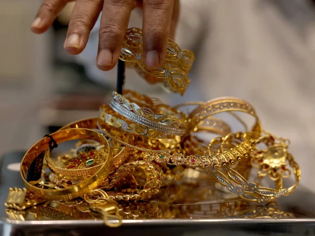a goldsmith weighs gold jewellery inside a showroom photo reuters