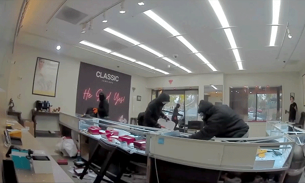 Video shows masked robbers crash car through jewelry store entrance, steal owner's gun in brazen heist