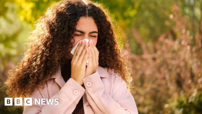 A woman in discomfort presses a tissue to her nose