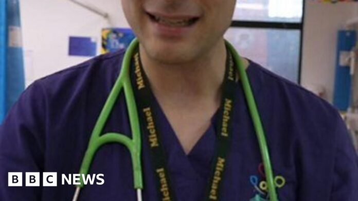A doctor wears blue scrubs and has a green stethoscope. 