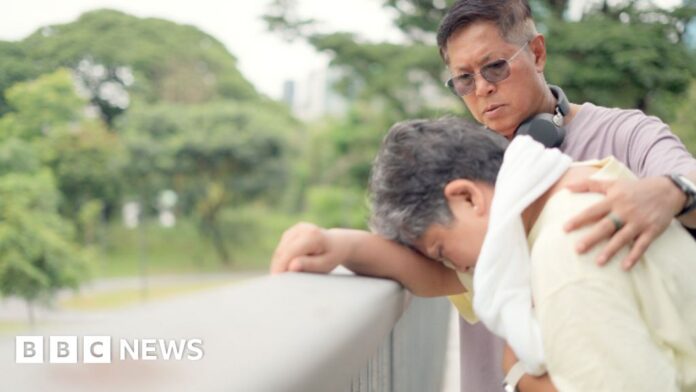 A woman leaning her head on railings with is being helped by a man