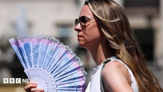 A pupil is sprayed with a fine mist as they drink water at the Harris Academy Primary Maxyflower school, as Britain experiences record temperatures disrupting schools and transport networks, in Grays, Britain, June 24, 2026. 