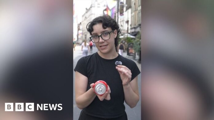 A person with short, dark curly hair wearing a black t-shirt took to the camera