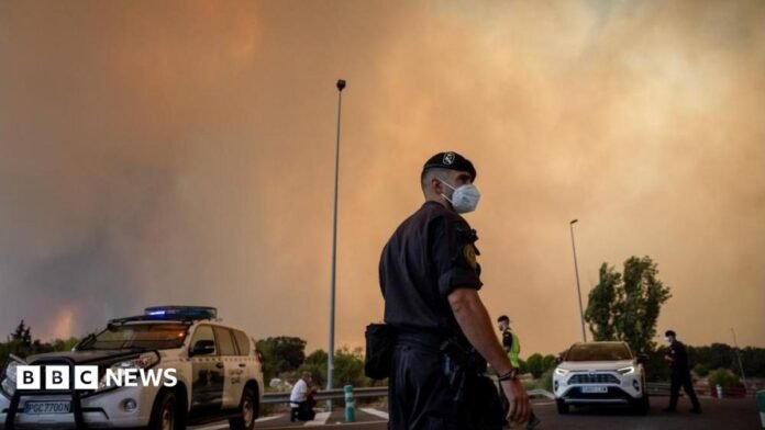 A person runs as the fire spreads in the mountains of Navaluenga, Avila, Spain