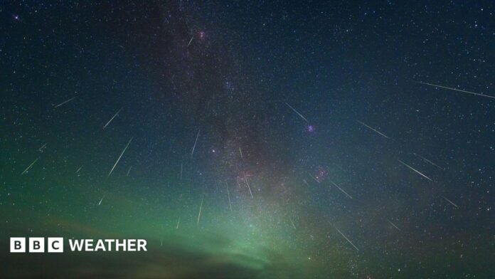 Different length white streaks radiate outwards from a colourful night sky