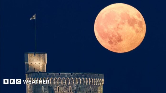 A large moon shining in a clear sky over Windsor Castle