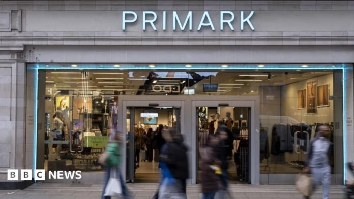 Shoppers, not in focus, walk past a Primark store in London