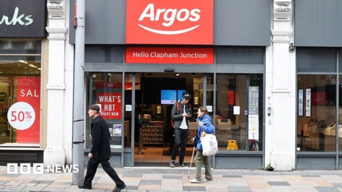 An Argos storefront in Clapham Junction. A young man is walking out of the shop while two people walk past it.