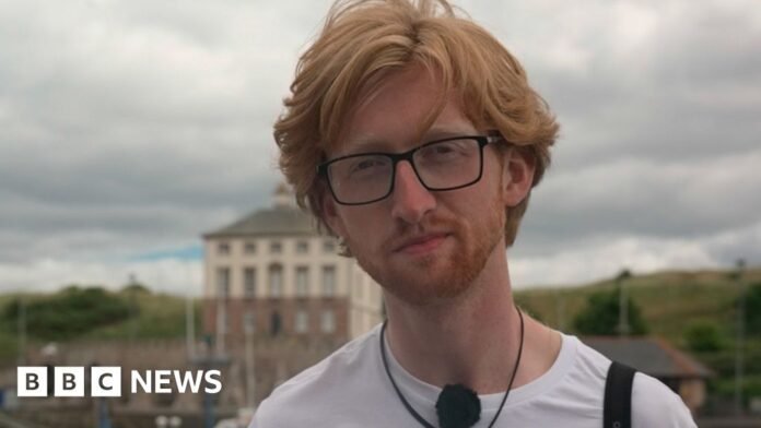 Patrick Safford at Eyemouth harbour, he has red hair, wears glasses and a white t-shirt with Berwickshire Marine Reserve on it