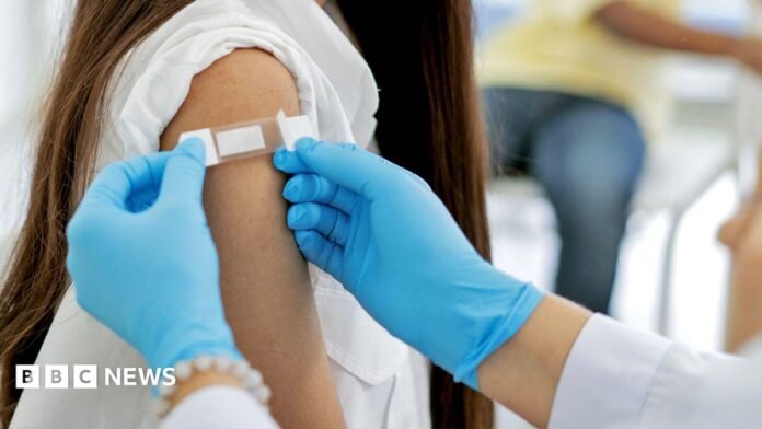 A girl having a plaster put on her arm after an injection