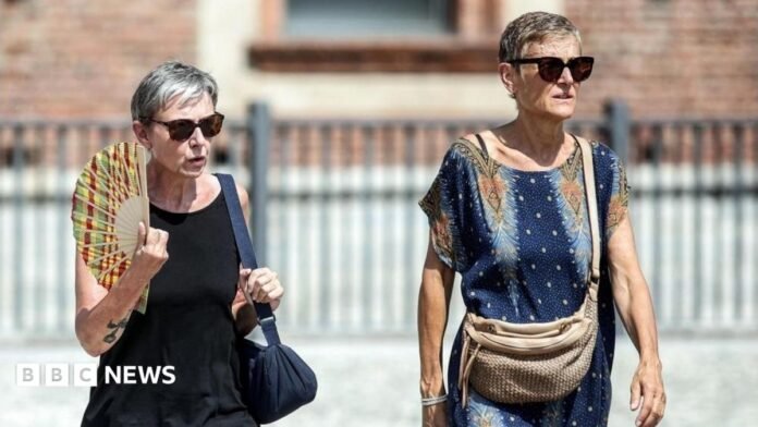 People drink water and use hand fans to protect themselves from the sun in Naples, southern Italy. Photo: 1 August 2026